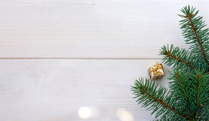 Christmas fir tree with gift box, snowflake and bokeh on a white wooden board and copy space for your text. Banner.Flat lay