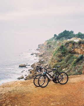 Two bikes on cliff near ocean