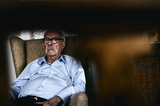 A 96 years old man. Grandfather sitting on a couch at home.