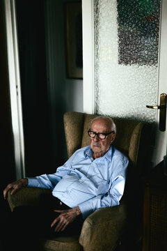 A 96 years old man. Grandfather sitting on a couch at home.
