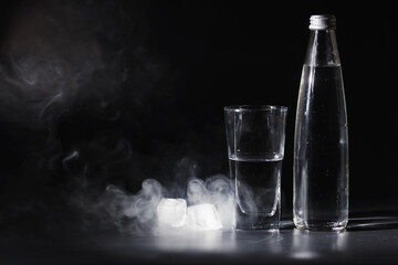 Close up pouring purified fresh drink water from the bottle on table in living room. Drinking water. Mineral vitamin water. Healthy, mineral-rich, refreshing water.