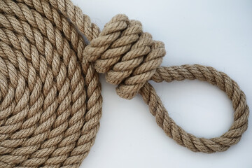 Braided thick rope tied in a skein. Hemp rope for decoration and design. Background from a fishing rope.