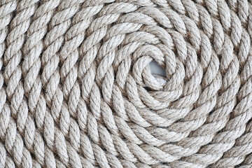 Braided thick rope tied in a skein. Hemp rope for decoration and design. Background from a fishing rope.