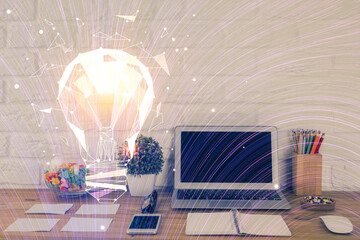 Computer on desktop in office with bulb icon hologram. Double exposure. Concept of idea.