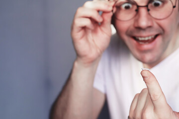 The concept of poor vision. Hold a contact lens and glasses in hand. A poster for advertising glasses and lenses.