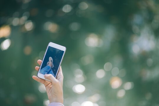 girl taking a photo feet on the lake