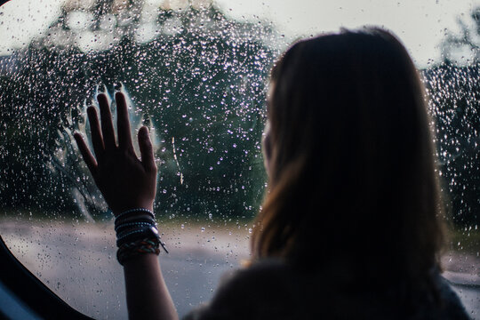 Young beautiful woman looking through the window while driving in the car