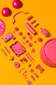 Organised Disassembled Clock/pink parts on orange background