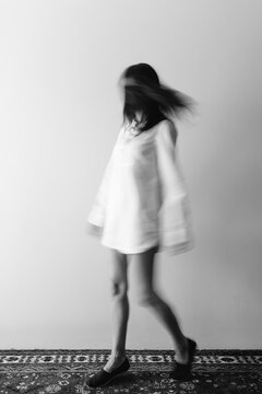 Black and White movement shot of woman wearing a long shirt