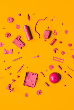 Organised Disassembled Clock/pink parts on orange background