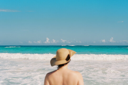 Woman in soft focus looks out across the ocean in the Caribbean
