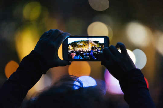Woman Shooting Photos of Crowd at Night