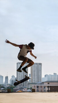 Skateboarder doing tricks on skateboard with cityscape in background.