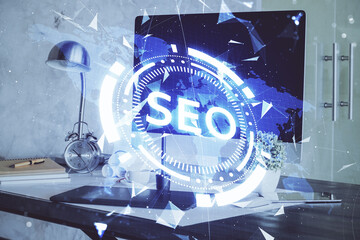 Multi exposure of table with computer and seo drawing hologram. Search optimization concept.