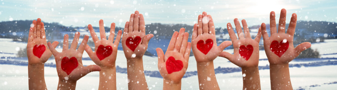 Many Kids Hands Showing Red Heart Symbols. Winter Snow Scenerey As Background