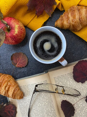 A mug of hot black coffee and an old book.