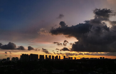 Warm sunset over city skyline with tall buildings in the foreground