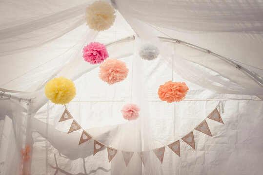 Wedding decoration, colorful pompons hanging in a white tent