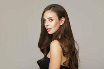 Naklejka premium charming brunette with long wavy hair. Hair and face care concept
