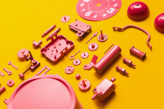 Organised Disassembled Clock/pink parts on orange background
