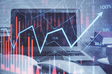 Stock market graph on background with desk and personal computer. Multi exposure. Concept of financial analysis.