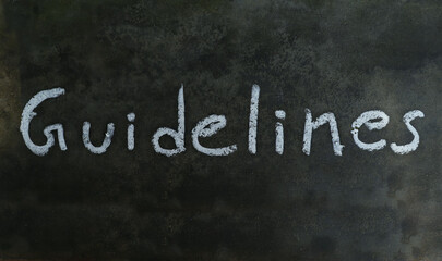 Guidelines Word Written on Blackboard with White Chalk