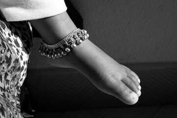 closeup shot of Indian girl child ankle bracelet isolated on bare feet