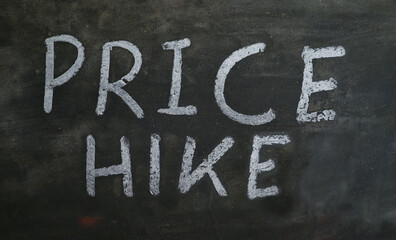 Fototapeta premium Price Hike Phrase Written on Blackboard with White Chalk