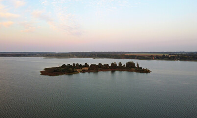 A view from the sky to a small forest island without anyone in a large lake