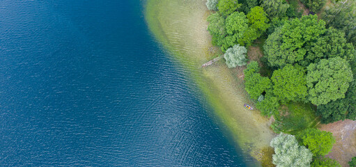 Aerial view of the Karskie lake shore and trees in Kinice, Poland