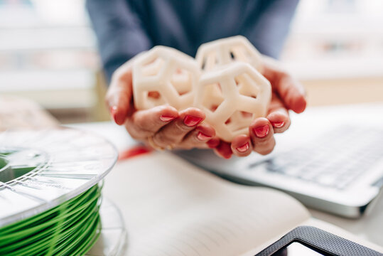 Engineer holding and inspecting 3d printed hexagon design samples