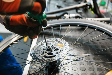 Bicycle assembly in workshop, man installs brake