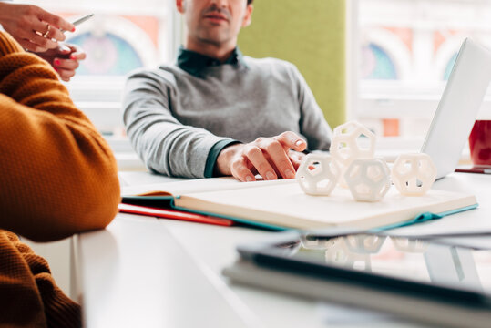 Engineering and design group of men and women examine 3d printed hexagon design sample
