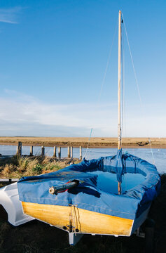 Covered sailing boat at Burnham Overy Staithe, Norfolk, UK.
