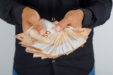 Young man in black shirt holding euro banknotes , front view.