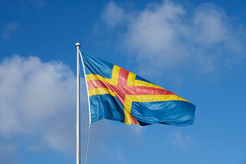 Flag of Ålands, Finland against a blue sky.