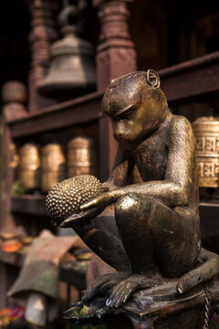 Statue of a monkey with a jackfruit on his hands.