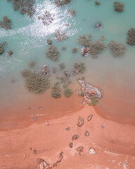 Drone view of red sand beach and turquoise water