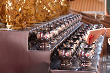 People put coins in the bowls of monks according to their beliefs and faith in religion.