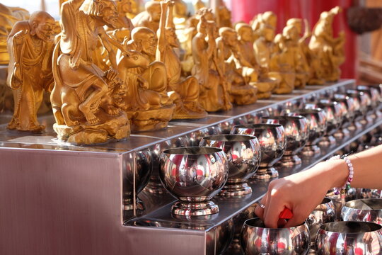 People put coins in the bowls of monks according to their beliefs and faith in religion.