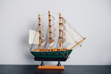 Small, wooden sailboat model on the table