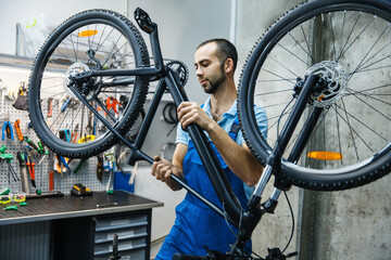Fototapeta na wymiar Bicycle repair in workshop, man checks mechanisms