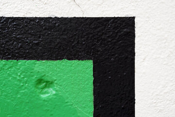Green and black paint on white wall as background and texture