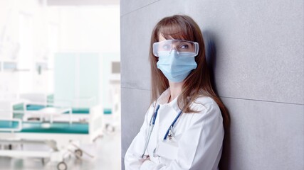 Covid-19 - Smiling female doctor in glasses on hospital corridor, Confident young woman.  