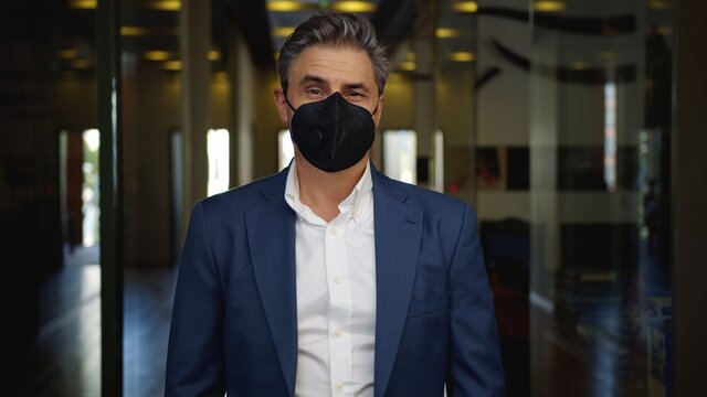 Covid-19 - businessman wearing face mask in empty office. Business in coronavirus quarantine times. 