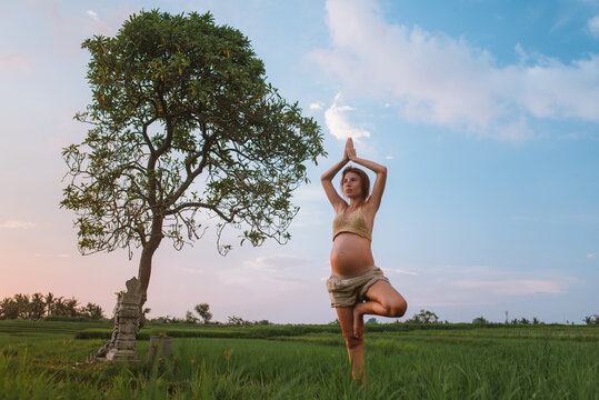 Pregnant Woman Doing Yoga In Nature