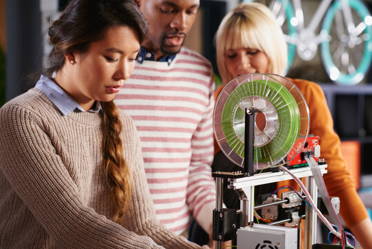 Group of engineer students working with 3D printer designing prototypes