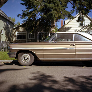 An old classic car parked along a residential street.