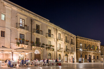 Fototapeta na wymiar Platz in Ortygia auf Sizilien bei sternenklaren Nachthimmel mit belebten Straßencafé