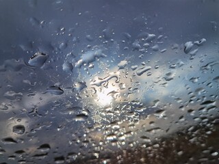 Fototapeta Szyba po deszczu z pojawiającym się wśród chmur słońcem obraz